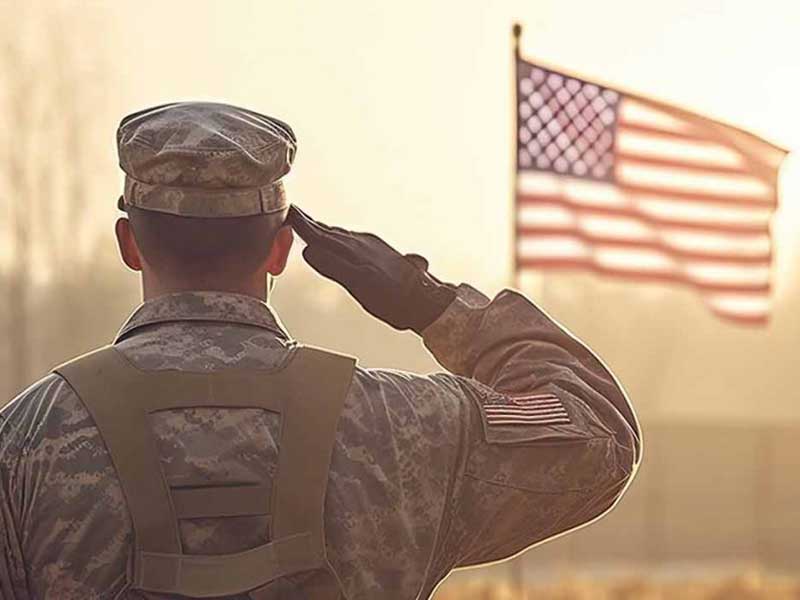 Military person saluting the American flag
